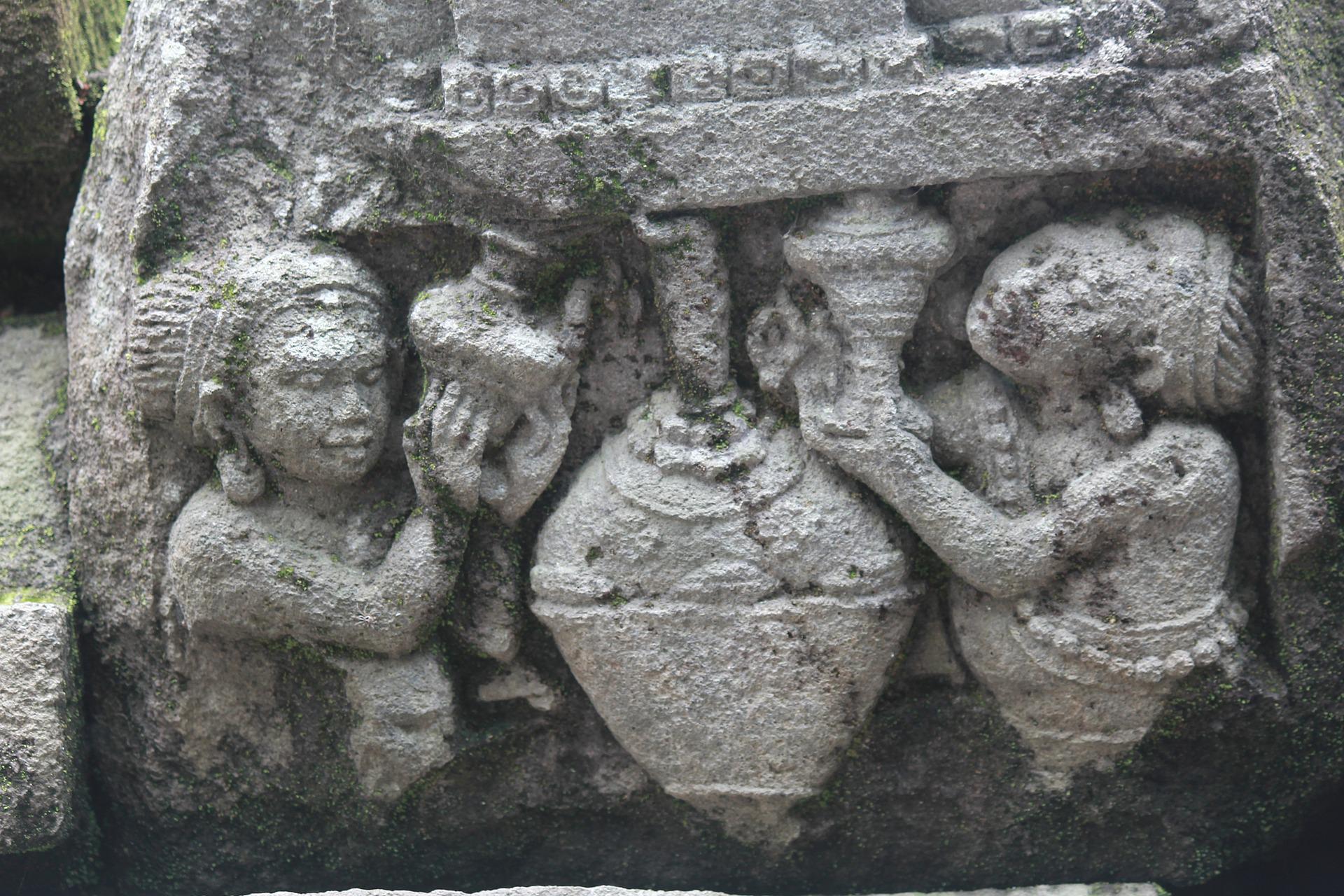 ancient stone carving of two women with pottery