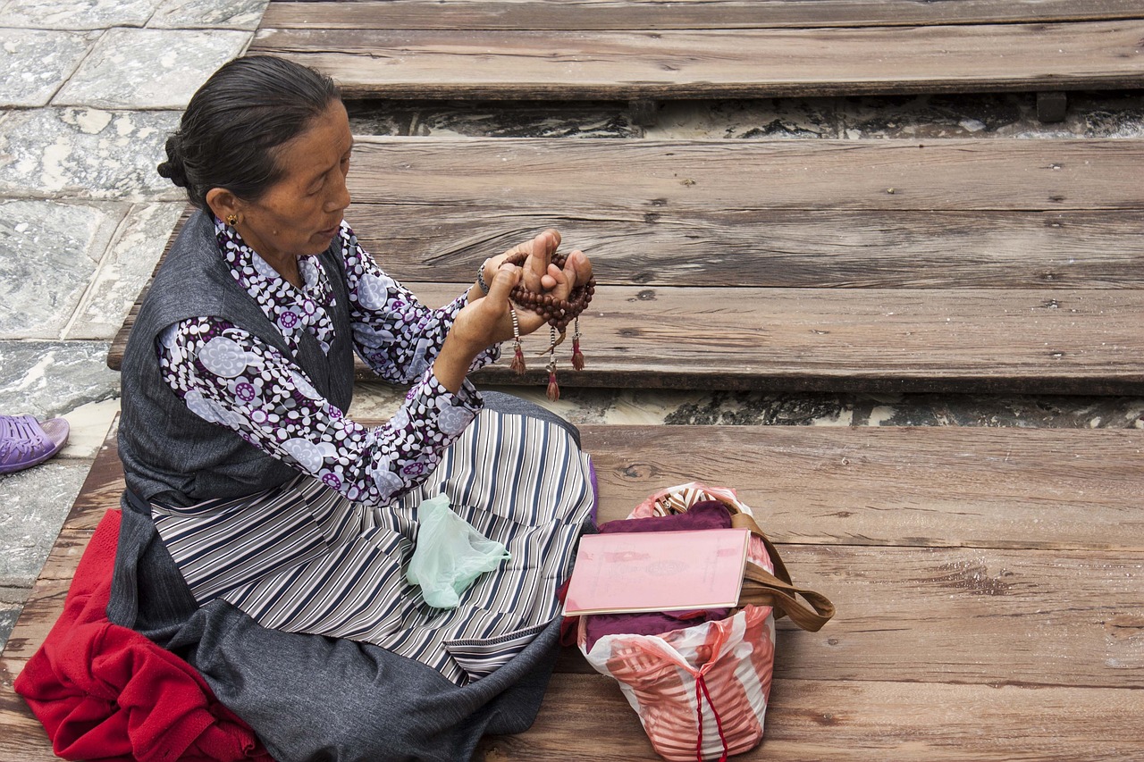 old Buddhist woman with prayer beads