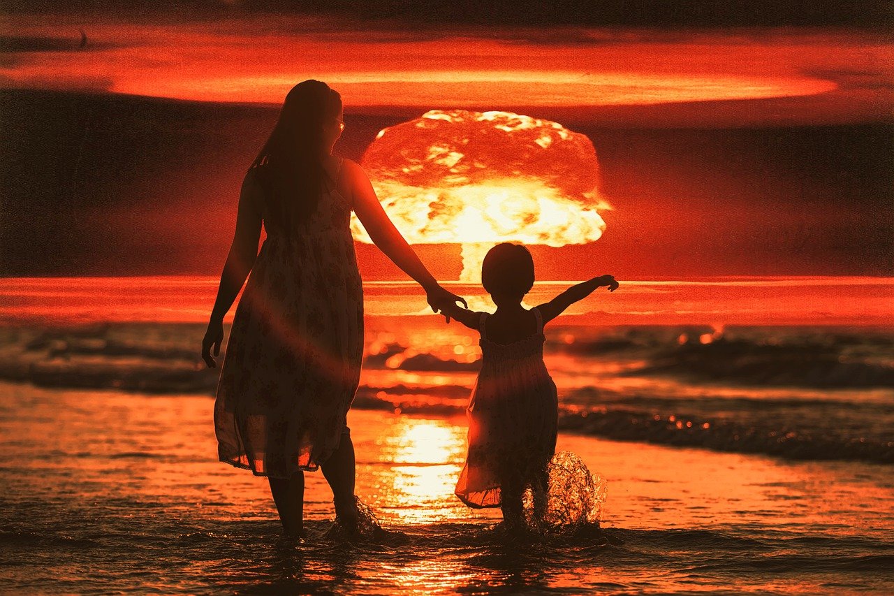 woman and child with atomic bomb explosion in background
