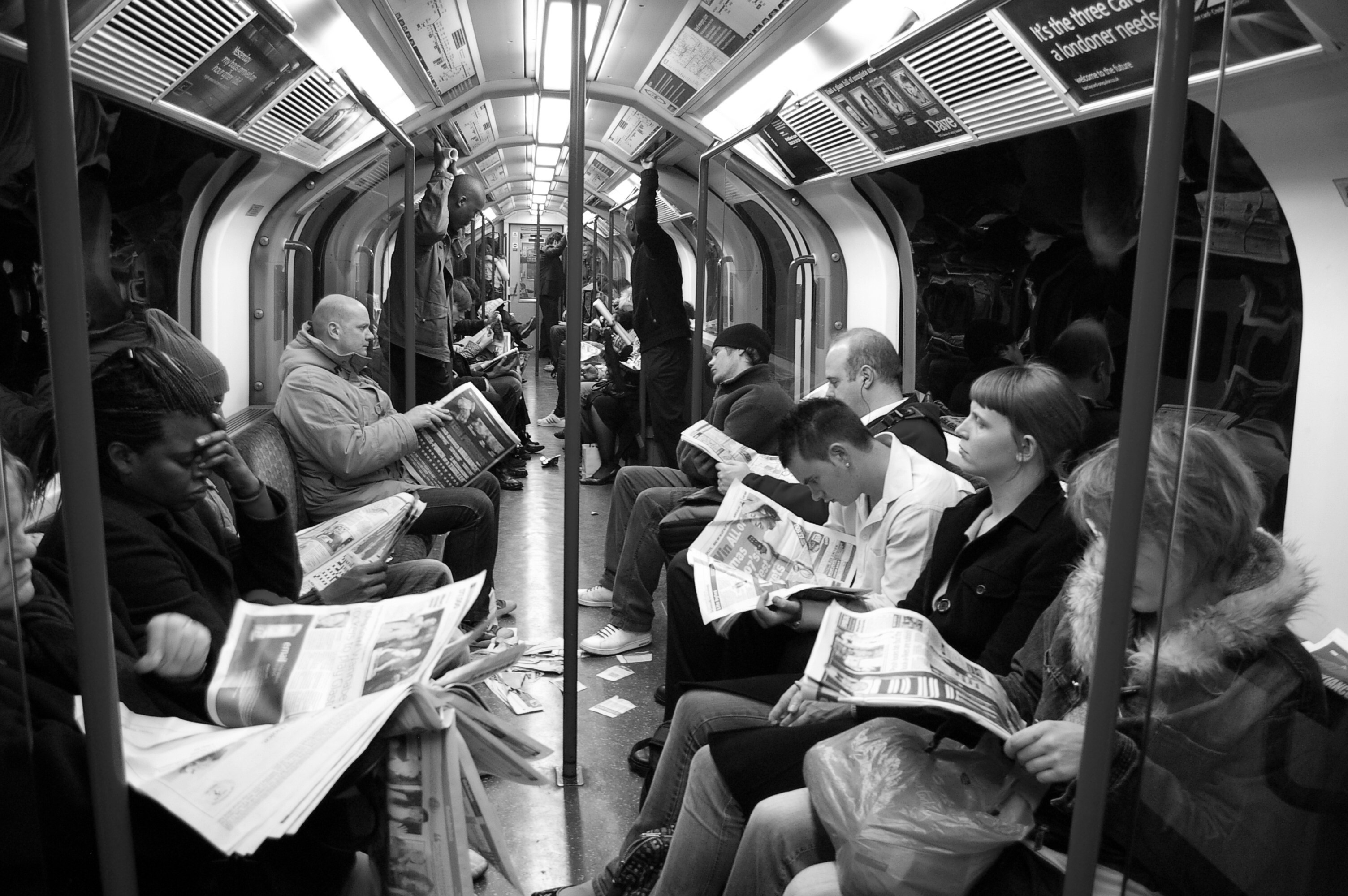 subway riders reading newspapers
